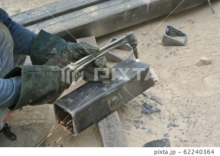 Workers at construction site cutting metal using blowtorch. Blowtorch produced very high temperature flame that able to cut metal in short time.  62240364