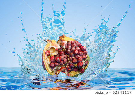 Pomegranate cut in half with water splashes 62241117