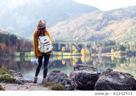 girl stands on the shore of a mountain lake 62242513