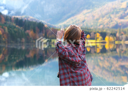 girl stands on the shore of a mountain lake 62242514