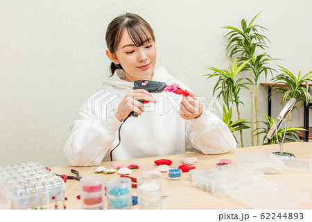 ハンドメイド　グルーガンを使ってアクセサリー作りをする20代の女性 62244893