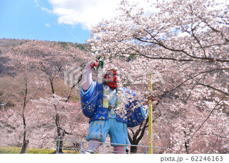 満開の桜を愛でる大きな天狗の写真素材
