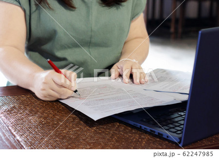 hand holding pen marking on paperwork in office 62247985