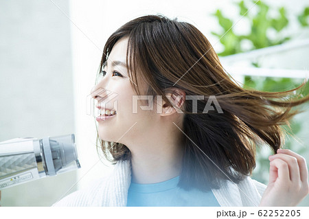 ドライヤーで髪を乾かす女性 62252205