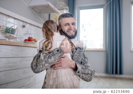 Serviceman dad returning home hugging little daughter. 62253690