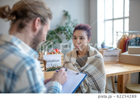 Young girl in plaid standing looking at the man opposite 62254289