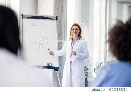 Group of doctors listening to presentation on medical conference. Group of doctors listening to presentation on medical conference. 62258334