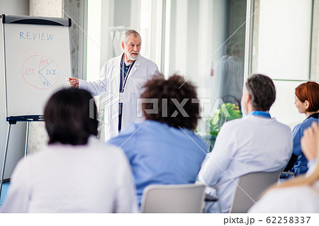 Group of doctors listening to presentation on medical conference. Group of doctors listening to presentation on medical conference. 62258337
