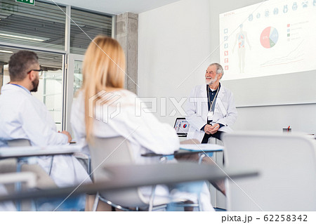 Group of doctors listening to presentation on medical conference. 62258342