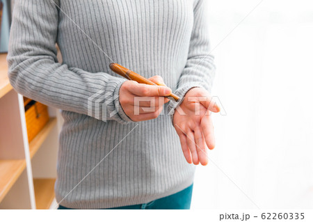 ツボ押し棒を使用する女性　様々な手のツボ 62260335