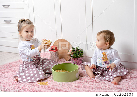 Sisters 1 and 3 years old girls sit on the floor Sisters 1 and 3 years old girls sit on the floor 62262104