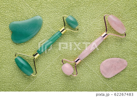 real jade facial roller and rose quartz on green 62267483