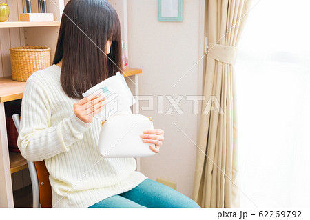 ナプキンをポーチから取り出す女性 62269792