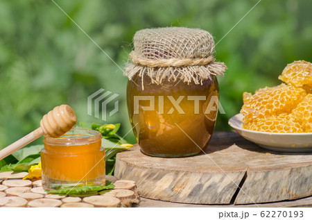 Honey in jar with honey dipper on rustic wooden 62270193