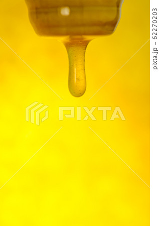 Honey stick with pouring honey. Flow of sweet 62270203