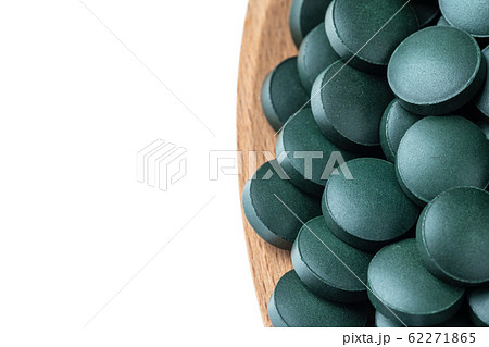 Vitamin and mineral supplements for vegetarians spirulina in tablets in a wooden spoon, close-up. 62271865