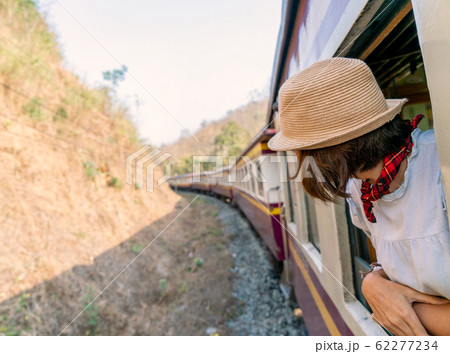 Woman looks out from window traveling by train in 62277234