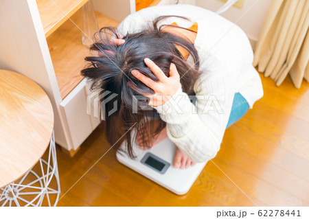 体重計に乗る女性　頭を抱える 62278441
