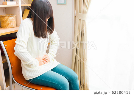 腹痛の女性　病気や妊娠など様々な症状 62280415