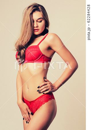 Sexy young woman in red lingerie posing on white Sexy young woman in red lingerie posing on white 62284428