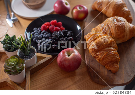 Succulents, croissants, berries, red apples on a wooden table Succulents, croissants, berries, red apples on a wooden table 62284884