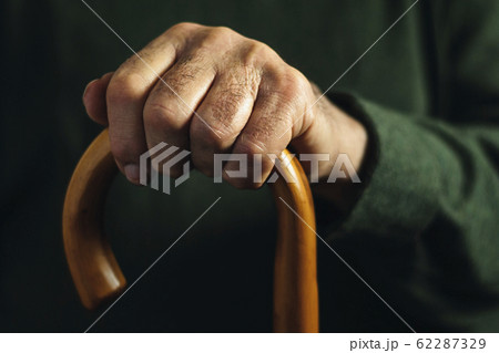 Hand of an old man holding a walking stick Hand of an old man holding a walking stick 62287329