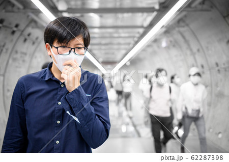 Asian man wearing mask coughing in subway tunnel Asian man wearing mask coughing in subway tunnel 62287398