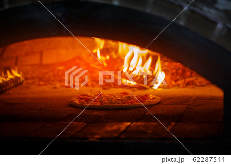 Pizza in the oven at the background of the fire 62287544