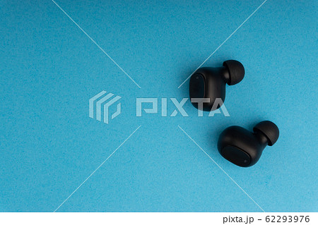 Wireless earbuds or earphones on blue background Wireless earbuds or earphones on blue background 62293976