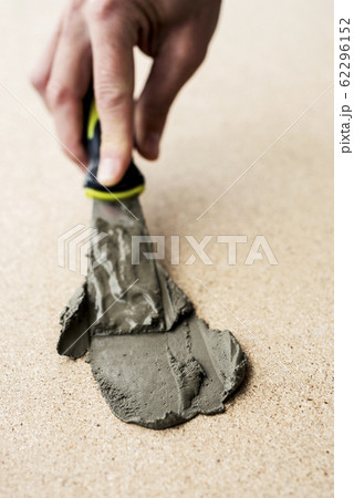 man spreading some concrete on a surface man spreading some concrete on a surface 62296152