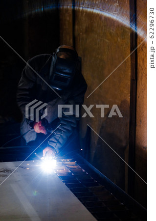 worker in protective uniform and mask welding metal. 62296730