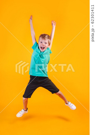 Portrait of jumping funny boy on color background 62301411