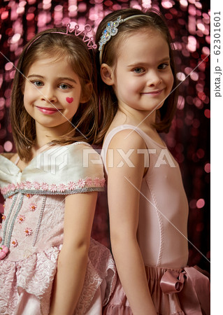 two adorable little girls are posing on the shiny background two adorable little girls are posing on the shiny background 62301601