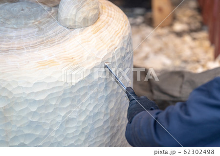Wood carver working on a large sculpture of Winnie the Pooh 62302498
