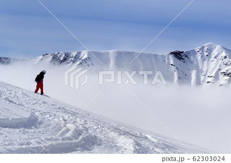 Snowboarder on off-piste slope with newly fallen 62303024