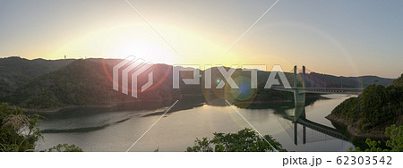 冬の日の出の羽路ダムと羽路ダム湖水橋のパノラマ風景 62303542