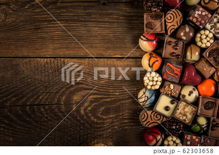 pralines on the wooden plank background 62303658