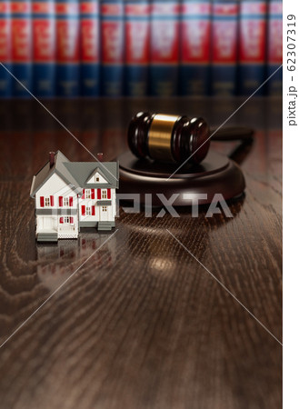 Gavel and Small Model House on Wooden Table. Gavel and Small Model House on Wooden Table. 62307319