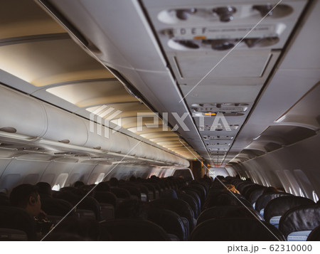 Interior of a plane with passengers on their seats 62310000