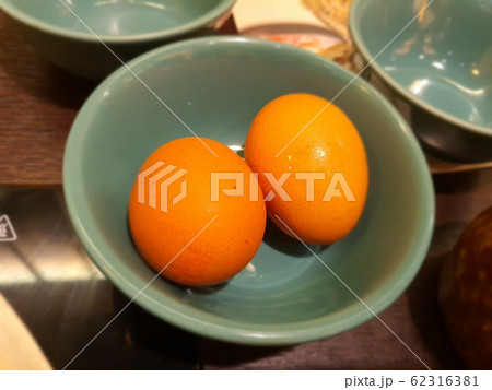 Close-up to top view of two chicken eggs in green bowl. Close-up to top view of two chicken eggs in green bowl. 62316381