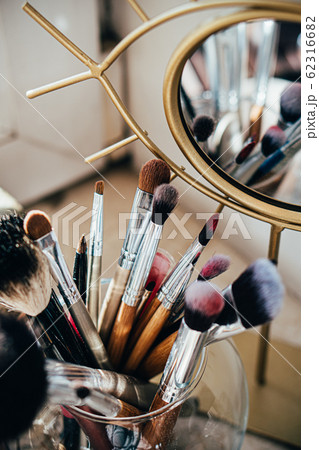 Many different makeup brushes in artist's studio with mirror reflection 62316682