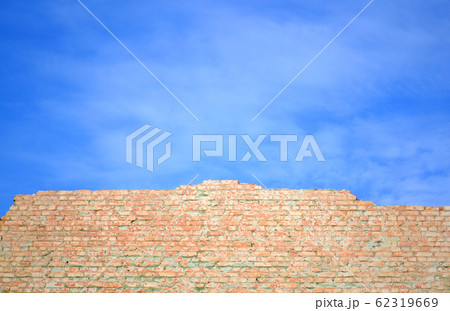 blue sky and brick wall wall of red brick shattered against the blue sky 62319669