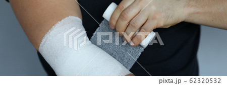 Male hand with tight elastic bandage on elbow closeup 62320532