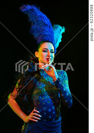 Beautiful young woman in carnival and masquerade costume in colorful neon lights on black background Beautiful young woman in carnival and masquerade costume in colorful neon lights on black background 62320898