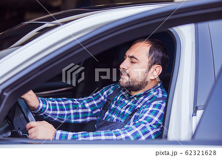 Side view of male driver in his car 62321628