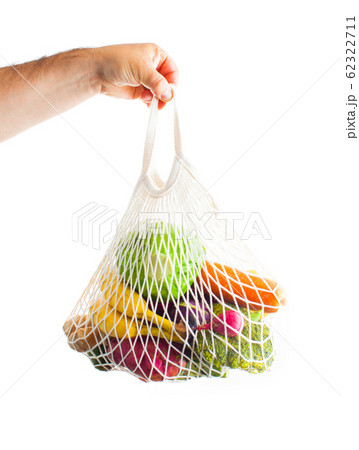 Hand holding white knitted shopping bag with grocery 62322711