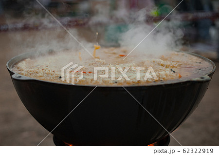 Cauldron with pilaf. Pilaf boils in a cauldron. Street food 62322919