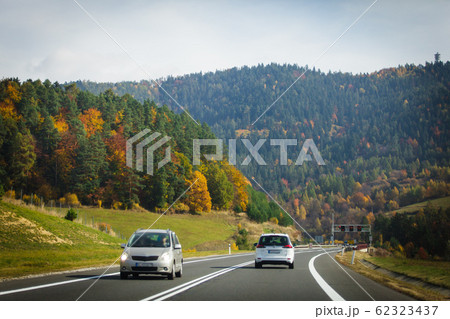 Cars driving on the asphalt road passing through the mountain 62323437