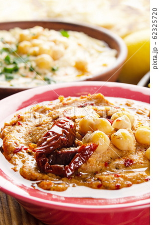 Fresh homemade Hummus in clay dish topped with 62325720