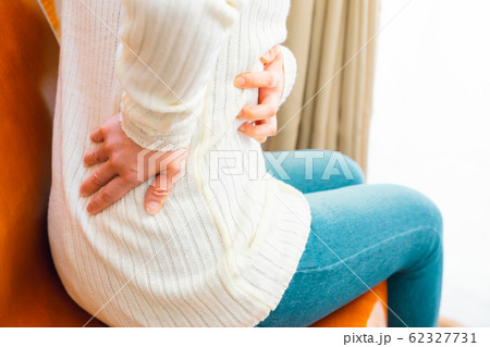 腰を抑える女性　腰痛など様々な症状 62327731